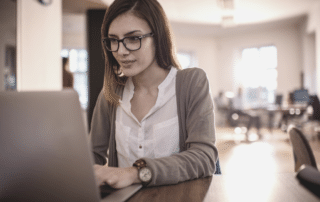 Building respect in your role: Advice for Assistants. Woman typing at desk.