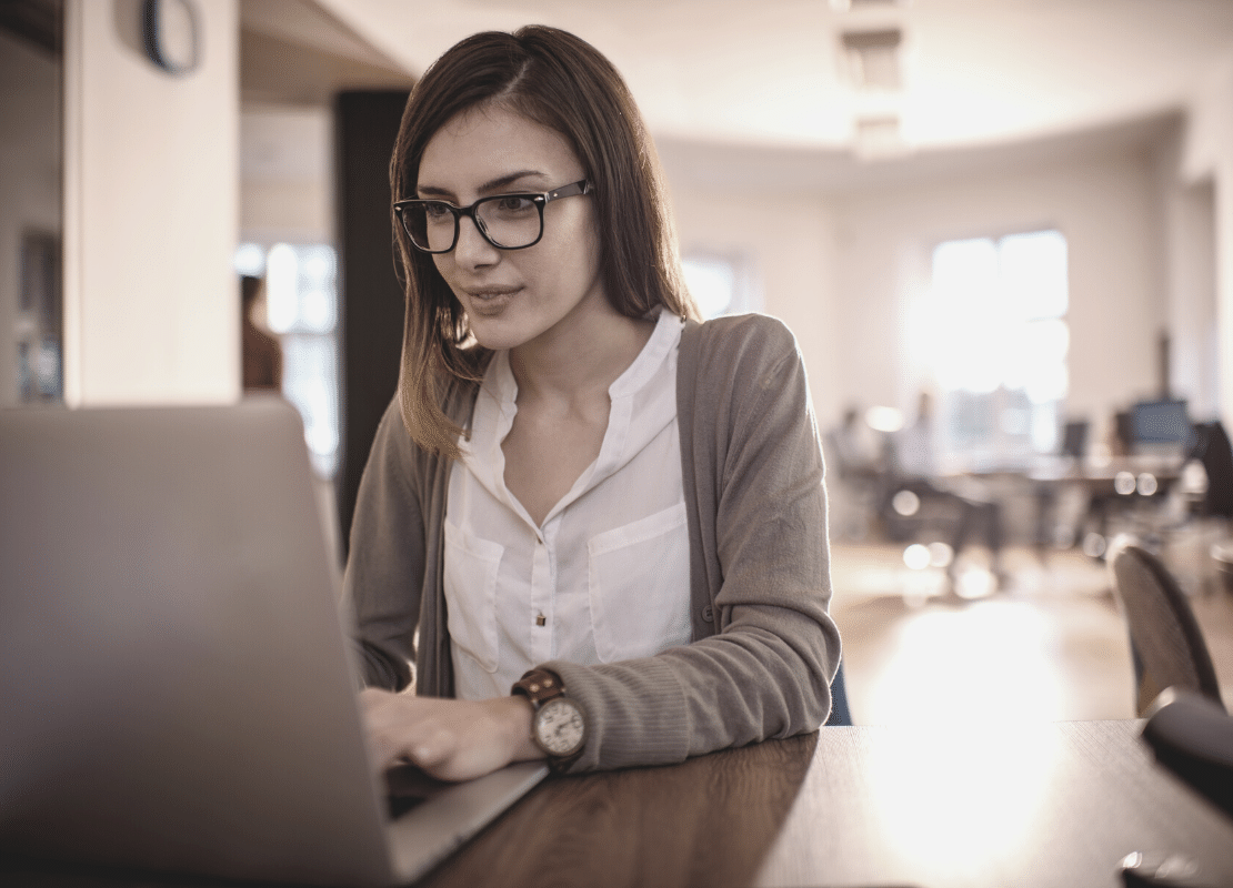 Building respect in your role: Advice for Assistants. Woman typing at desk.