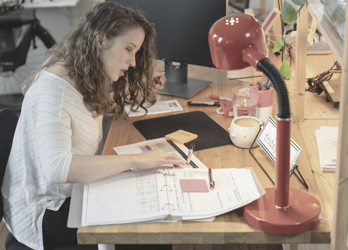 How to be an Assistant that adds value. Woman working at desk.